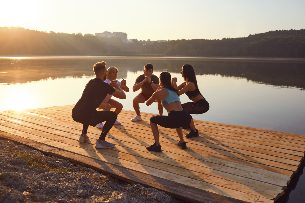 A Group of Sports People Doing Squat Exercises Outdoor